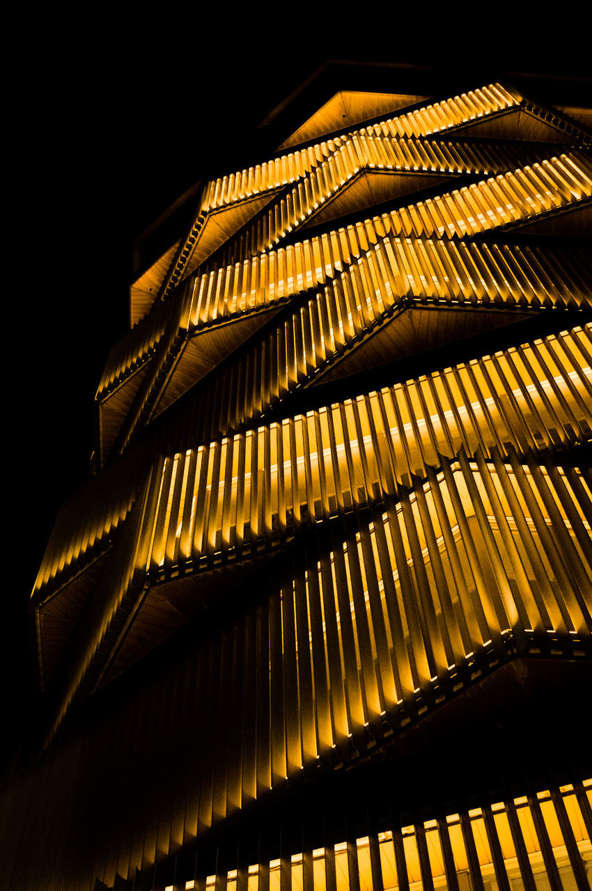 low angle view, pattern, illuminated, night, no people, architecture, built structure, indoors, glowing, dark, nature, roof, gold colored, close-up, building, lighting equipment, modern, metal, black background, ceiling