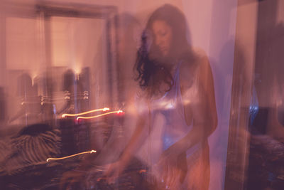 Blurred motion of young woman playing music at home