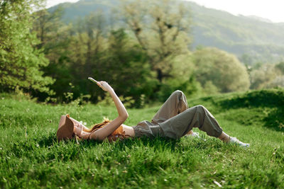 Side view of woman sitting on field