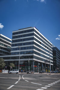 Low angle view of modern buildings against blue sky