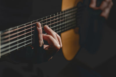 Midsection of man playing guitar