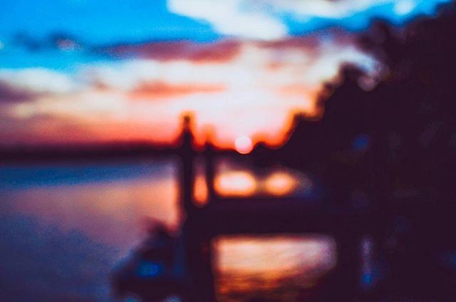 sunset, silhouette, sky, orange color, dusk, selective focus, defocused, focus on foreground, beauty in nature, one person, nature, cloud - sky, outdoors, tranquility, water, outline, scenics, dramatic sky, cloud, illuminated