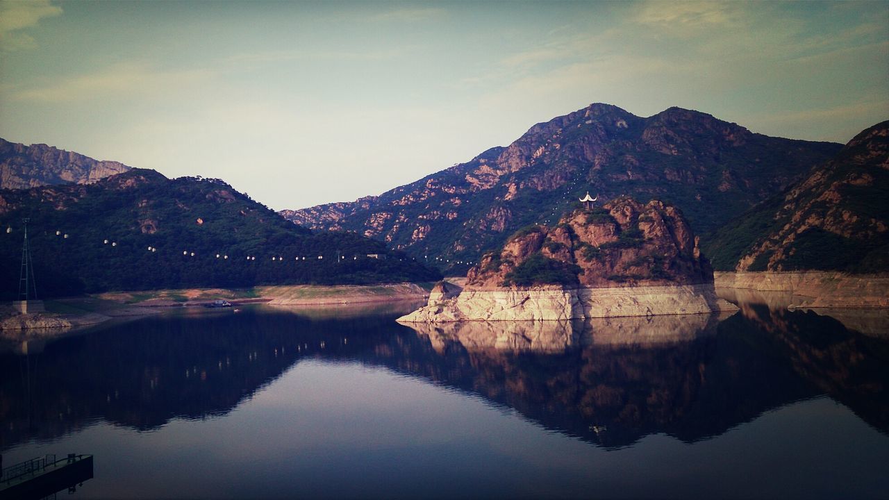 mountain, water, reflection, waterfront, lake, tranquility, tranquil scene, mountain range, scenics, sky, river, beauty in nature, nature, standing water, built structure, non-urban scene, idyllic, no people, outdoors, landscape