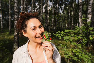 Woman in forest eating wild berries summer day natural food healthy eating theme