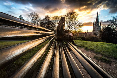 Tilt image of cross on field against sky at sunset