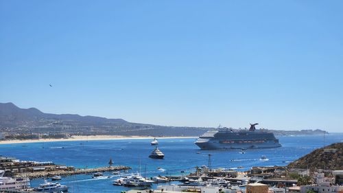 Boats, yachts and a cruise in sea against clear blue sky