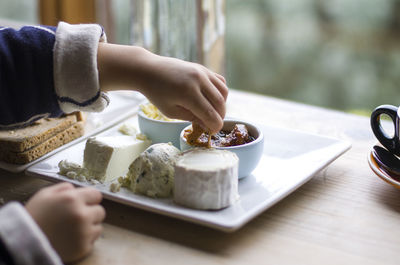 Cropped hand of person holding food in plate