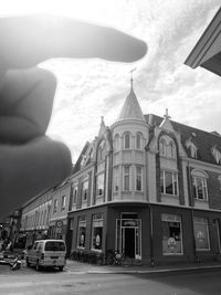 Cars on city street against sky