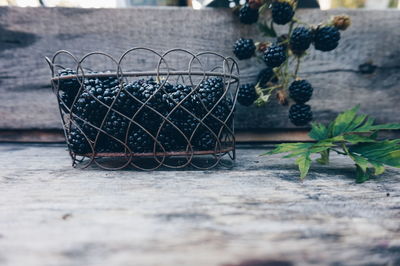 Close-up of blackberries in metal container on wooden table