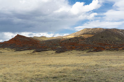 Scenic view of field and mountains against sky