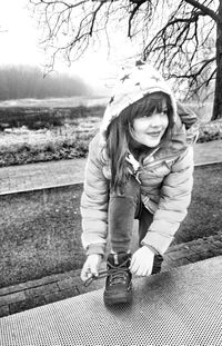 Portrait of happy girl sitting on tree