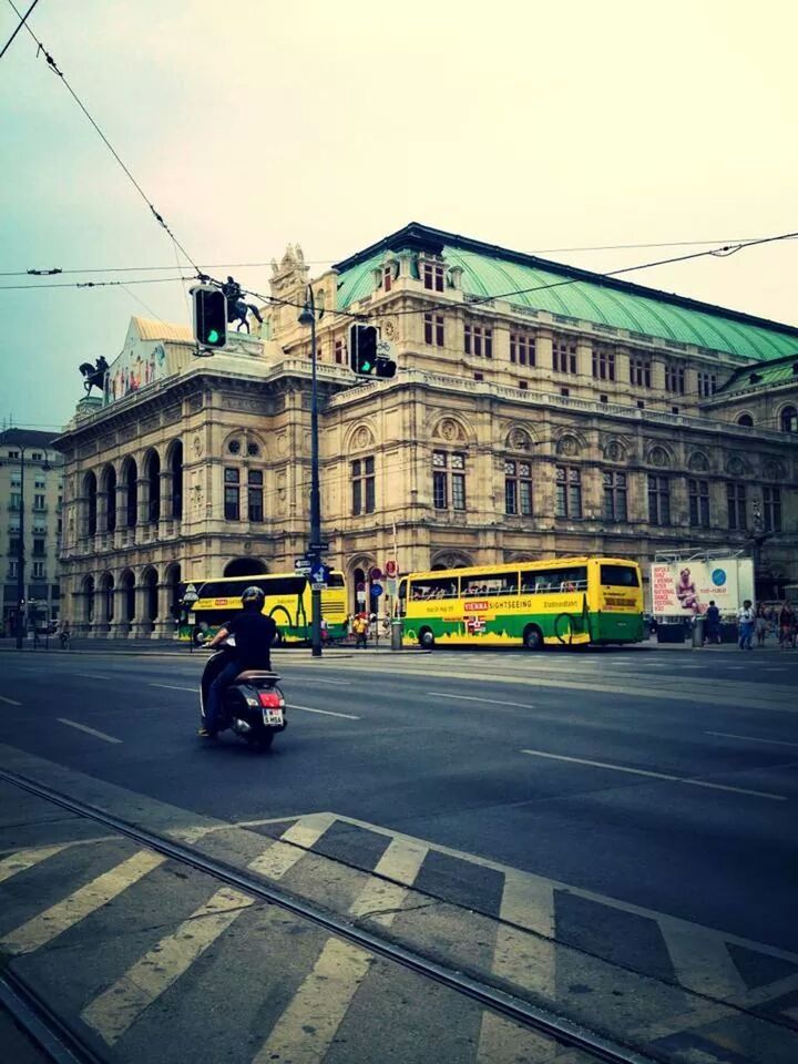 architecture, building exterior, built structure, transportation, street, city, men, land vehicle, mode of transport, car, road, city life, walking, city street, person, lifestyles, on the move, road marking, incidental people