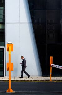 Side view of man standing against building