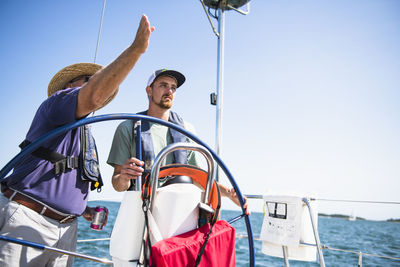 Man learning how to navigate during a family sail on sunny summer day