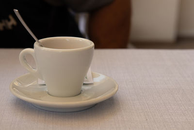 Midsection of woman holding coffee on table