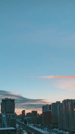 Buildings in city against sky during sunset