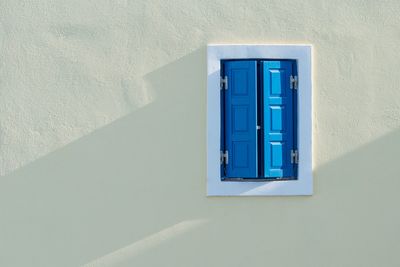 Blue window on white wall of building