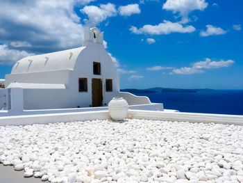 White building by sea against sky