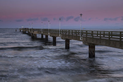 View of long bridge at calm sea