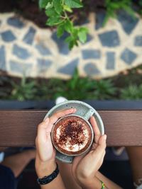 High angle view of hand holding coffee cup