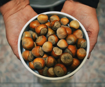 High angle view of hand holding eggs in bowl