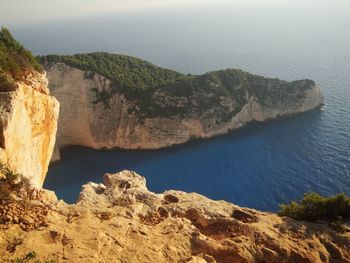 Rock formations by sea against sky