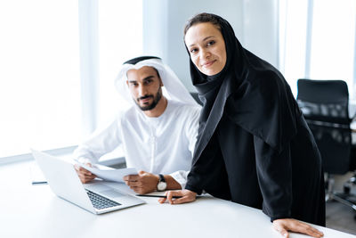 Portrait of smiling businesswoman using laptop at office