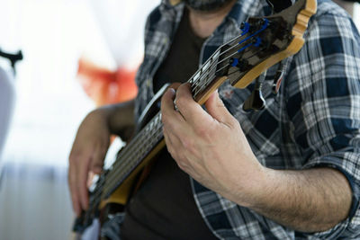 Midsection of man playing guitar