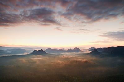 Tourist resort. fantastic dreamy sunrise on top of the rocky mountain with view into misty valley