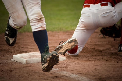 Low section of man and shoes on field