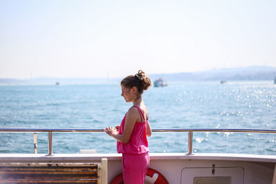 Young woman looking at sea against sky