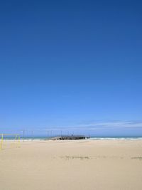 Scenic view of beach against blue sky