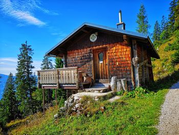 Old wooden house on field against sky