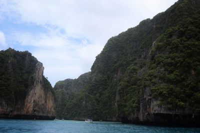 Scenic view of sea by mountains against sky