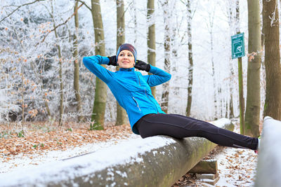 Woman with arms raised in forest