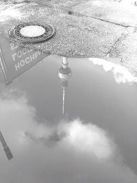 Reflection of communications tower in puddle