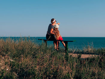 Full length of young woman in sea against clear sky