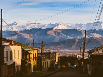 Houses and snowcapped mountains against sky