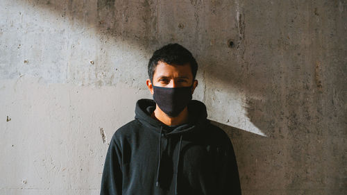 Portrait of man standing against wall