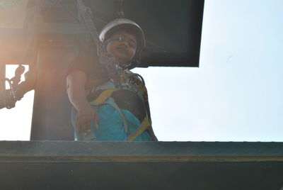 Low angle view portrait of boy standing on bungee jumping platform