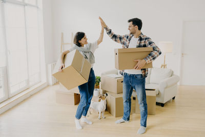 Couple holding boxes on home