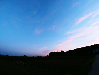 Scenic view of silhouette field against sky during sunset