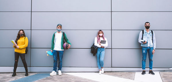 Portrait of people standing against wall