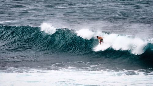 Man surfing on waves in sea