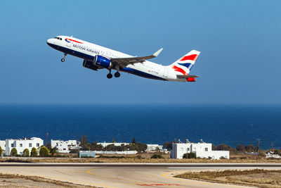 Airplane flying over sea against sky