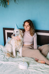 Full length of woman sitting against wall