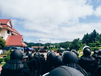 Rear view of people on street against sky