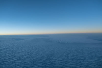 Scenic view of snow covered landscape against clear blue sky