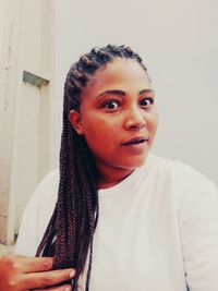 Portrait of young woman against wall at home