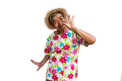 Woman with arms raised standing against white background